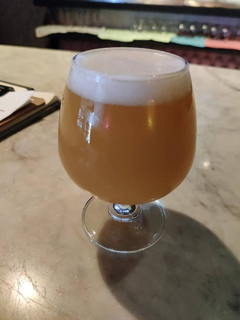 Cloudy IPA craft beer in a goblet style glass on the stone counter at Haze bar  in Bangkok, Thailand.