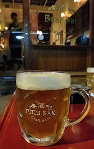 branded mug of craft beer in front of Pijiu craft beer bar in Bangkok