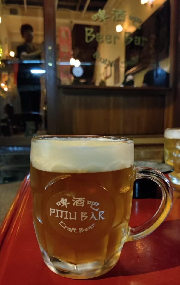 Glass / schooner of beer in a Pijiu Craft beer Bar branded glass in Bangkok Thailand.