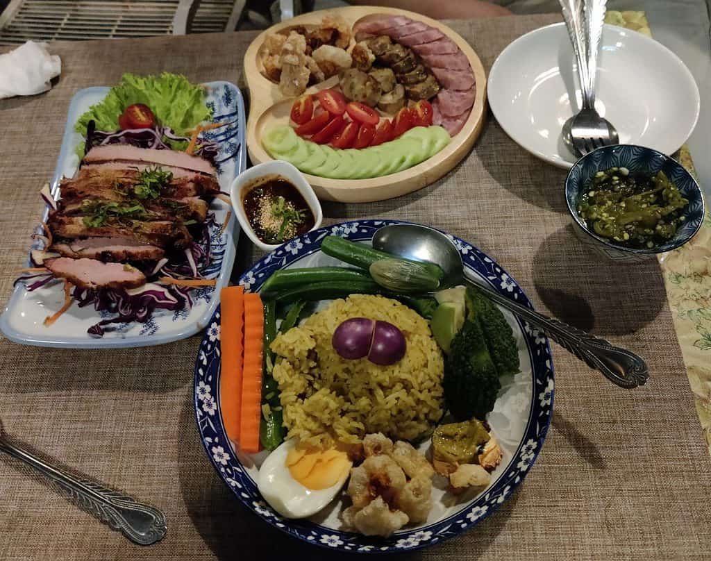 Food dishes served at Dok Kaew house bar, Bangkok. Includes pork neck on the left, a fried rice at the bottom, and sausages, including a fermented sausage at the top.