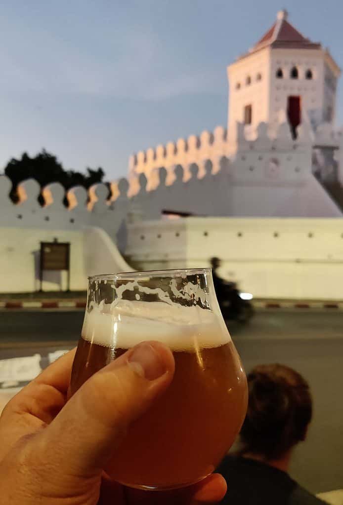 Holding a glass of craft beer with the 18th century Phra Sumen Fort in northwest Bangkok. View from Yolo craft beer bar.