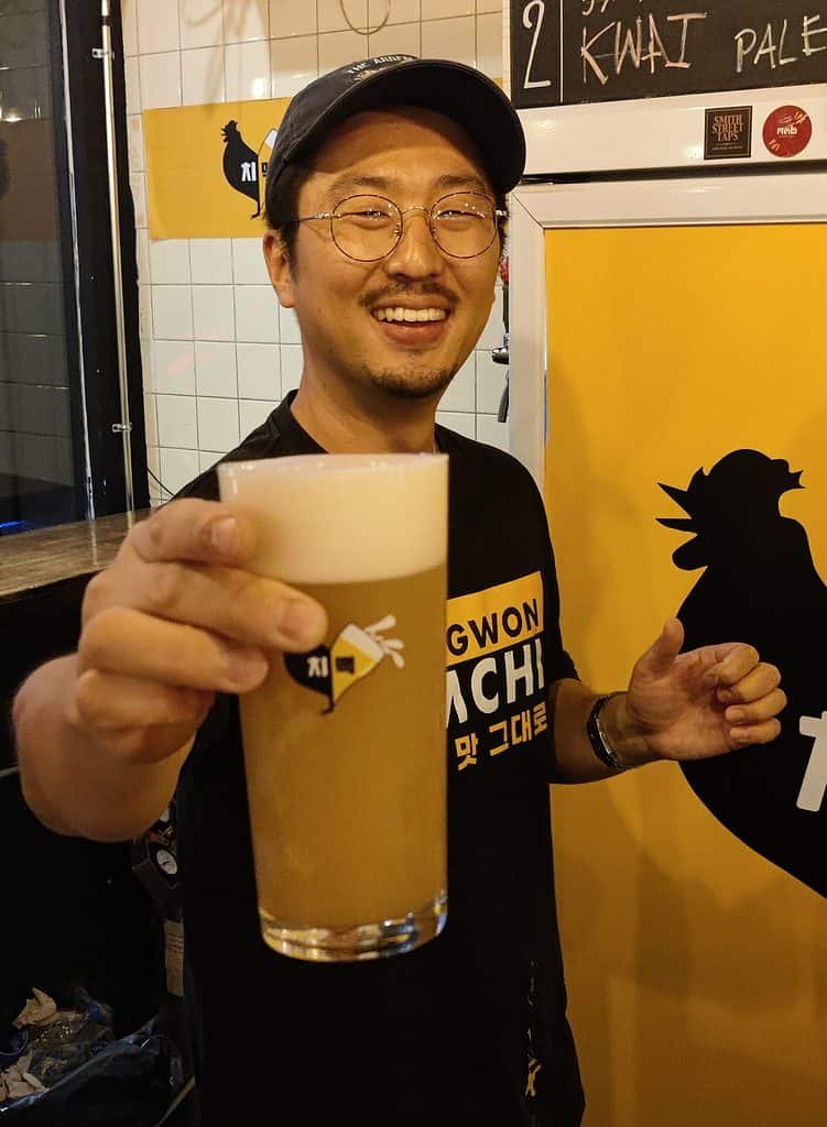 Owner of Changwon Express serving a pint of craft beer.
