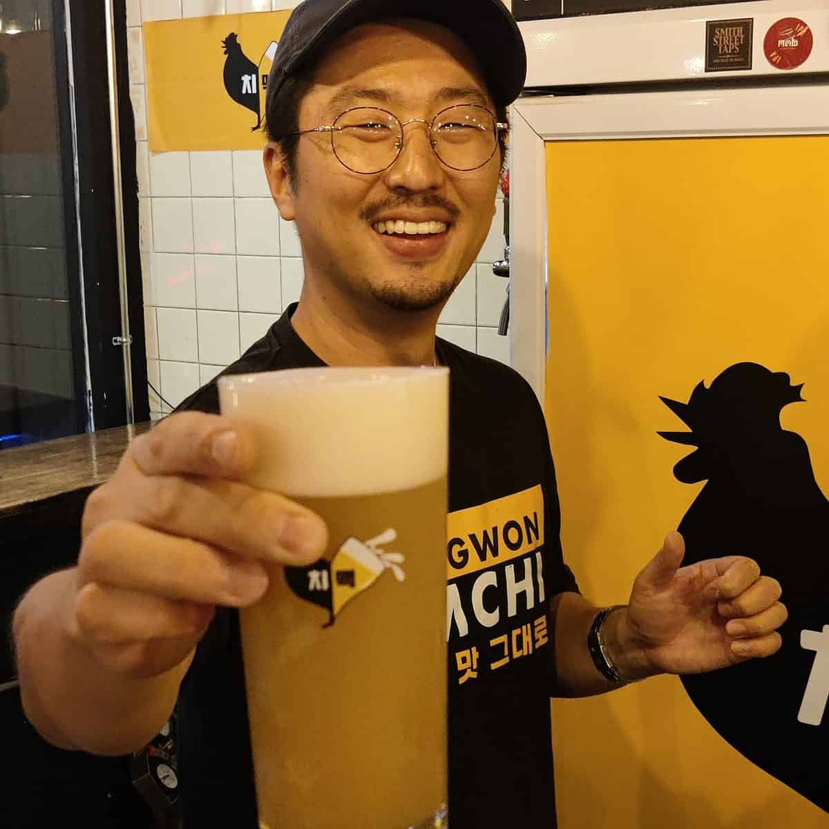 Owner of Changwon Express serving a pint of craft beer.