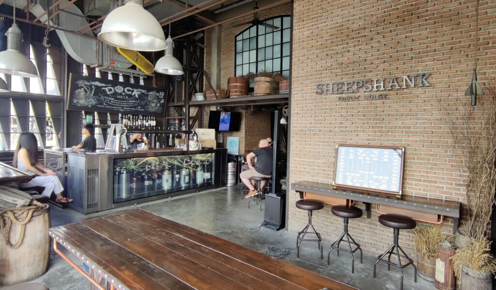 Wooden table at Sheepshank Public house & showing the bar of Dock No. 13 in Bangkok Thailand.