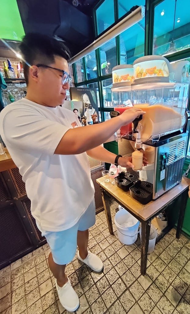 Samata slushy being pored from a slushy machine by the brewer himself at O'glee in Bangkok Thailand.