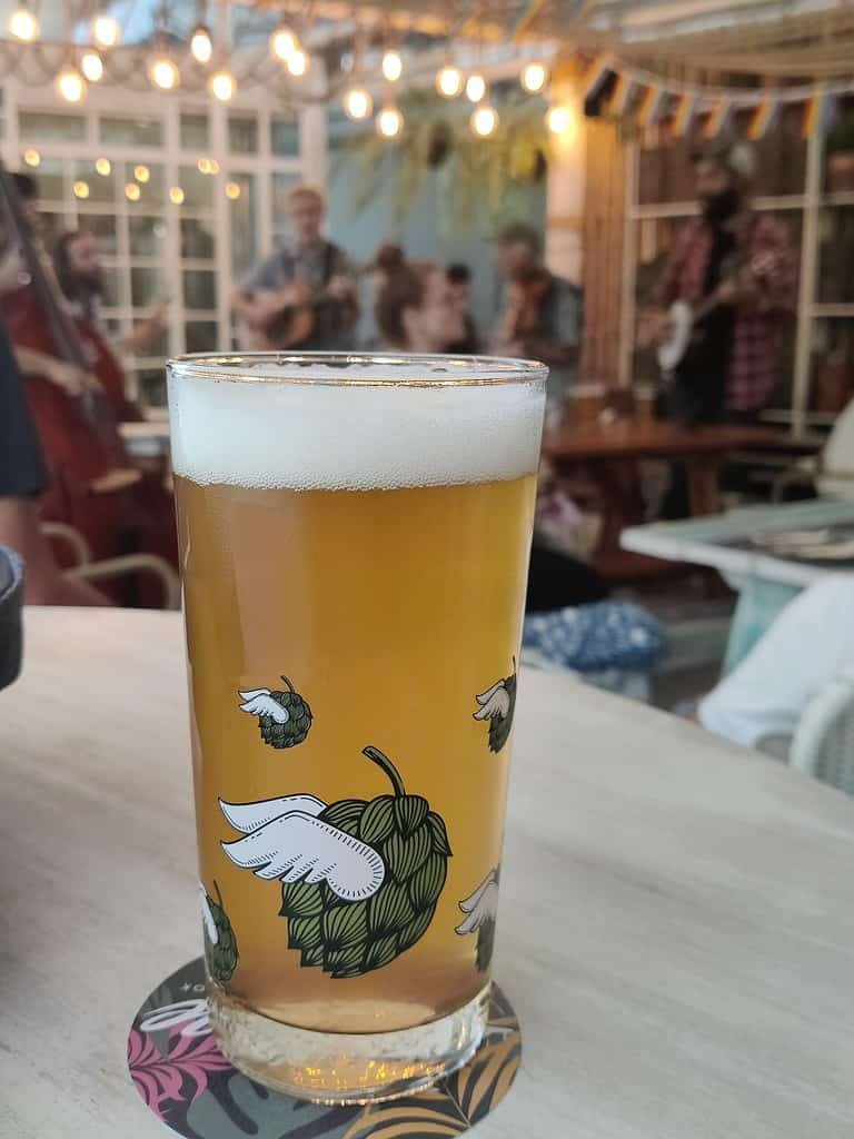 Pint of IPA Thai craft beer and Bluegrass band playing behind at Bootleg Brothers Brewpub; brewed fresh in Bangkok Thailand. Located at the top of Escape in EmQuartier mall. 