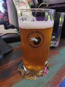 Glass of beer in a Bootleg Brothers branded glass in Bangkok Thailand