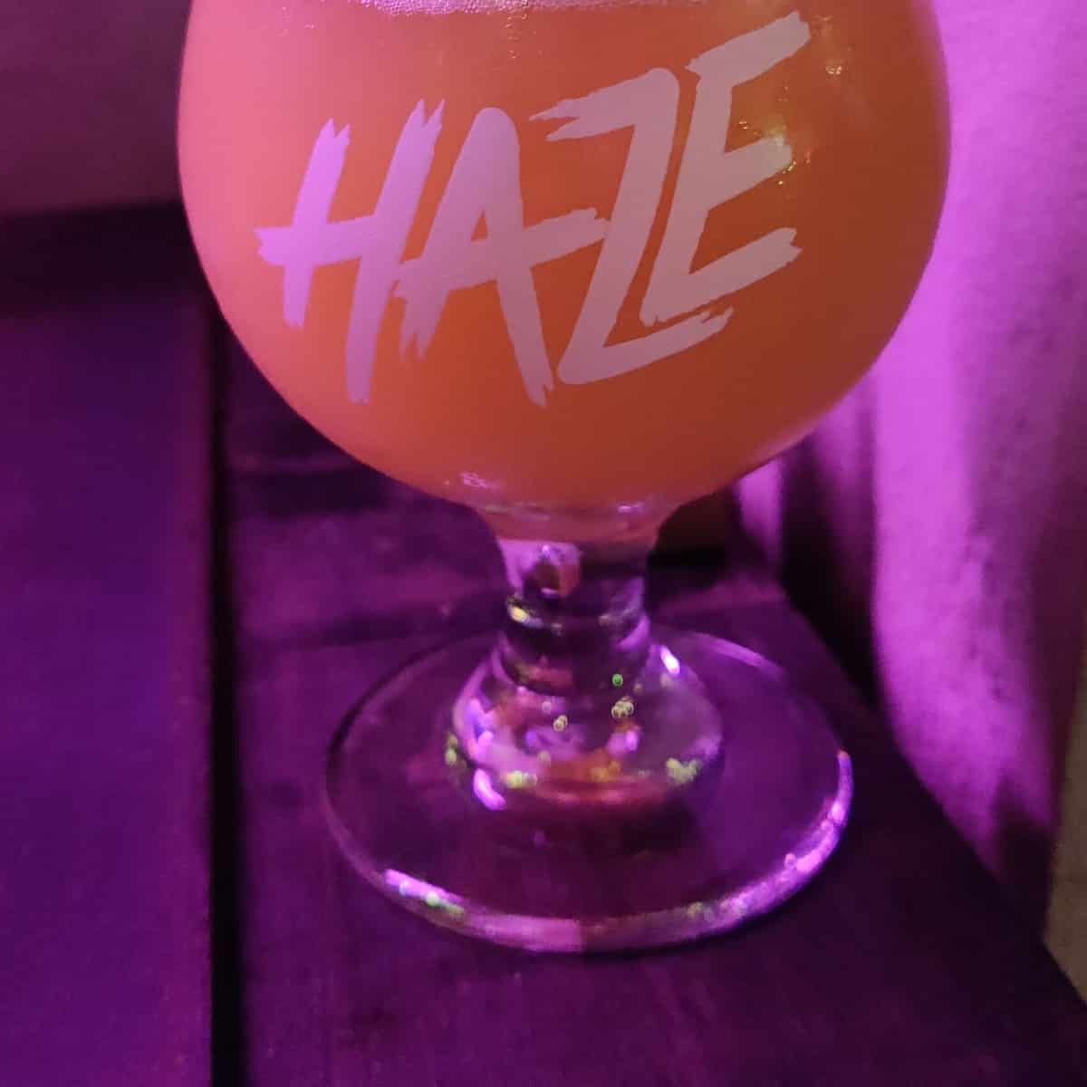 a hazy beer in a Haze branded craft beer bar glass in Bangkok Thailand