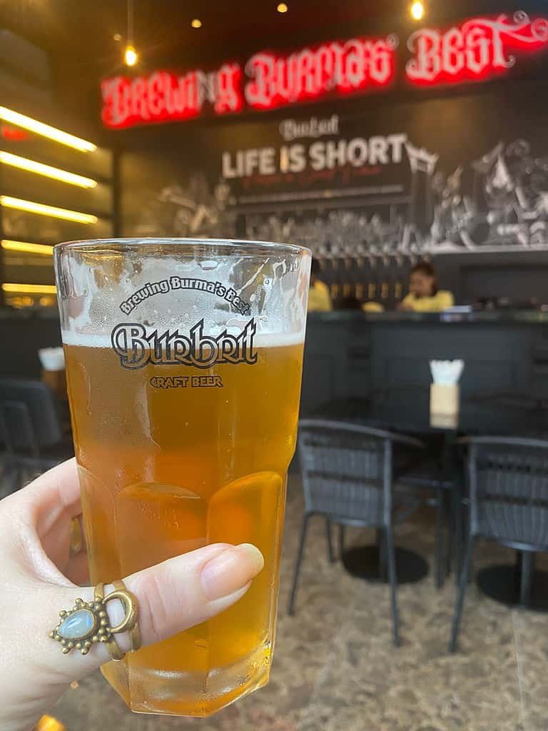 Woman's hand holding a  glass of beer in Burbrit craft beer bar in Bangkok Thailand