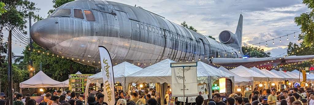 Beer Market 2 by ประชาชนเบียร์ (Beer People) at Chang Chui Creative Park in Bangkok.  Large airplane above the brewery tents and beer drinking crowd in Thailand's capital. 