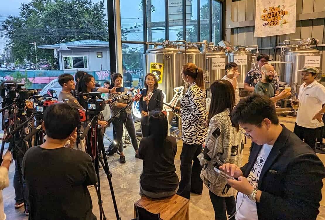Thai Craft beer week press conference - Ms. Prapawee Hematat, Executive Director, Group B giving a talk in front of the cameras and reporters in front of the beer tanks at United People's Brewery in Bangkok Thailand