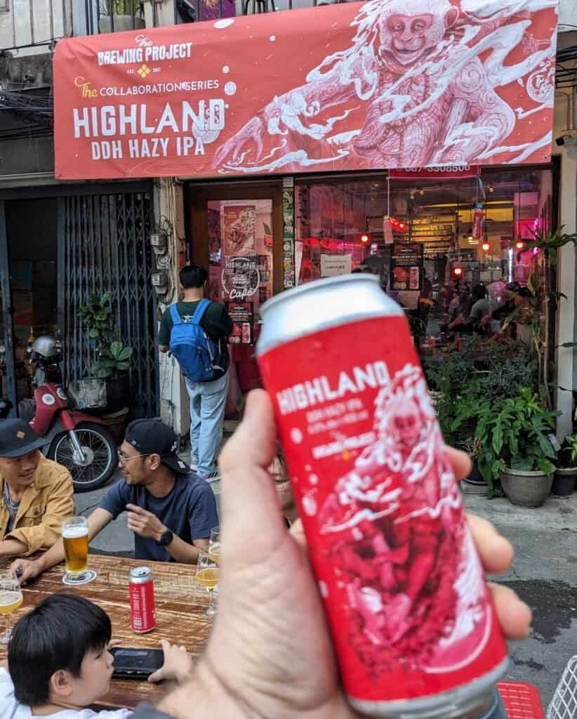 A can of the Brewing Project and Highland Cafe in Bangkok Thailand. Banner is posted on the shop storefront.
