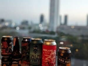Cans of Thai craft beer with Bangkok in the background.