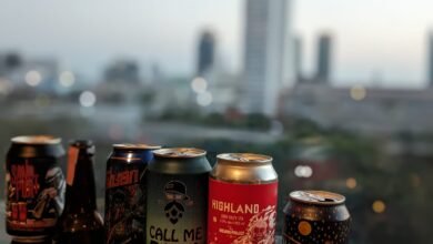 Cans of Thai craft beer with Bangkok in the background.