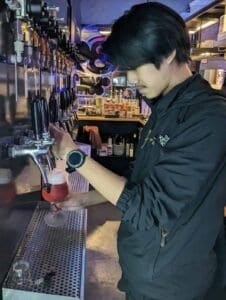Bartender pouring a craft beer at 39 Craft Coffee in Bangkok Thailand